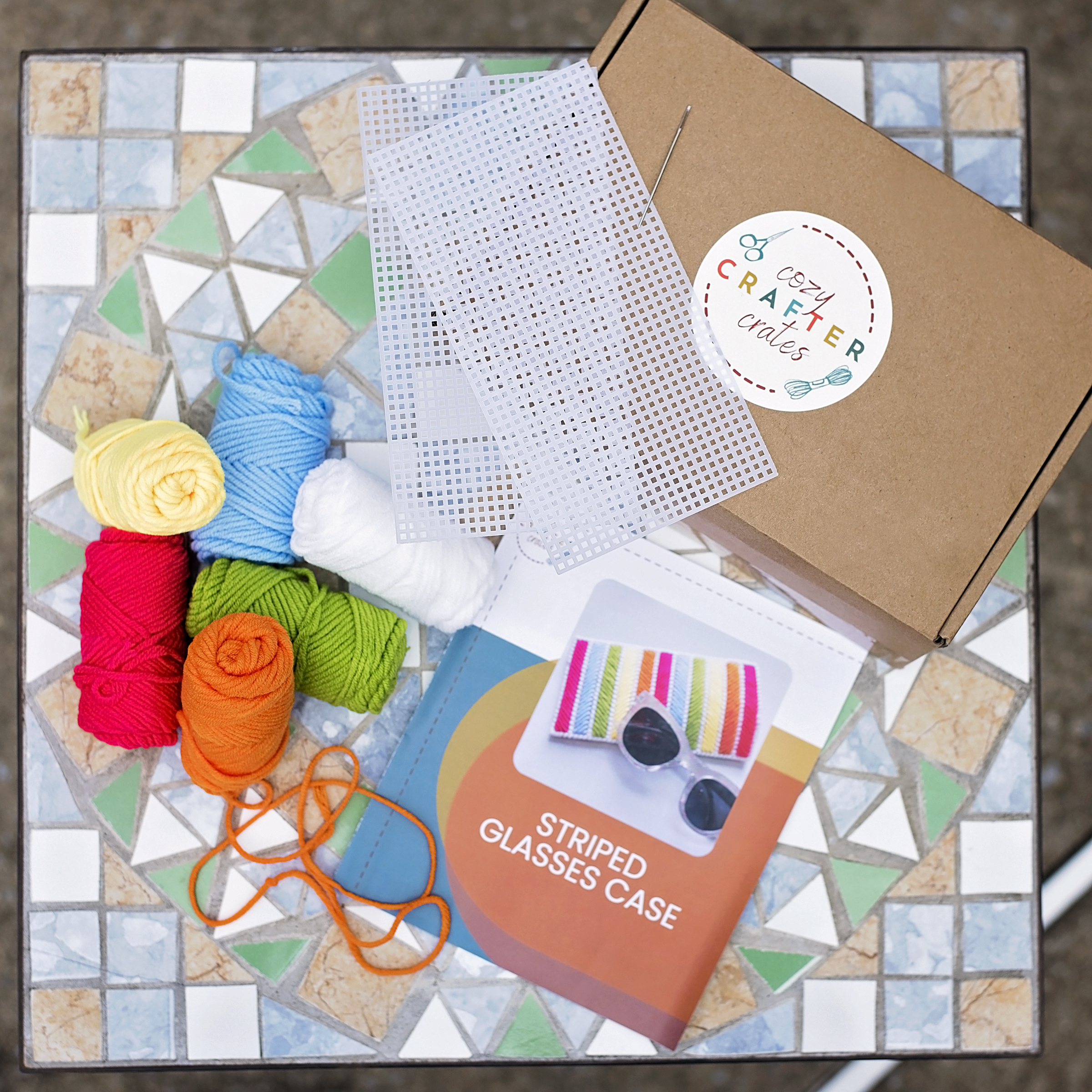 Hands arranging colorful craft supplies and materials on a wooden table