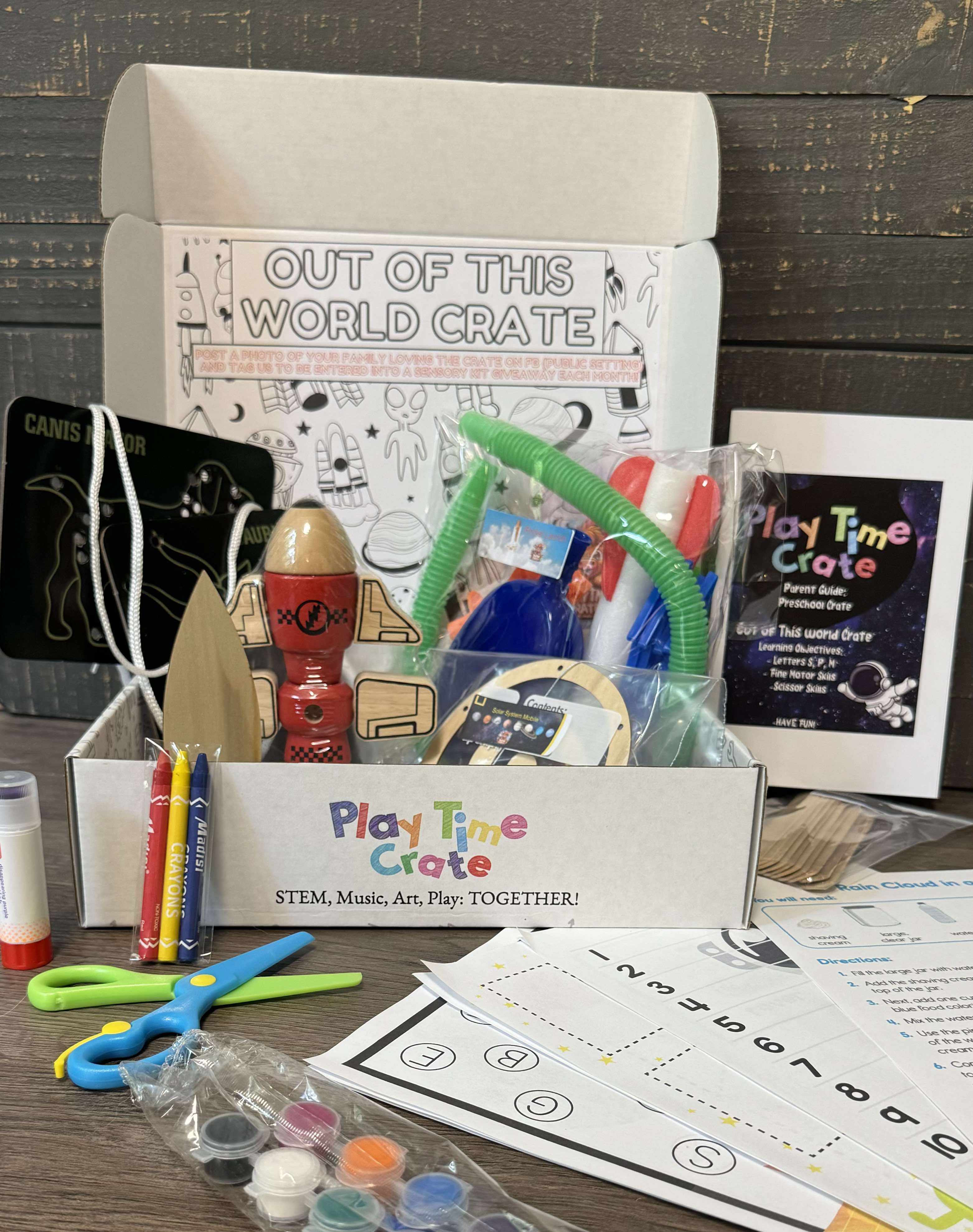Open Play Time Crate box showing the Out of This World theme, supplies, and parent guide