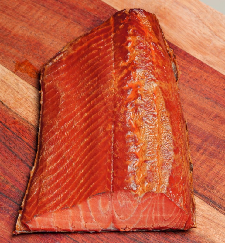 Smoked Sockeye Black Pepper - vacuum-sealed salmon fillet by Long House Fish Co with red label on rustic wood