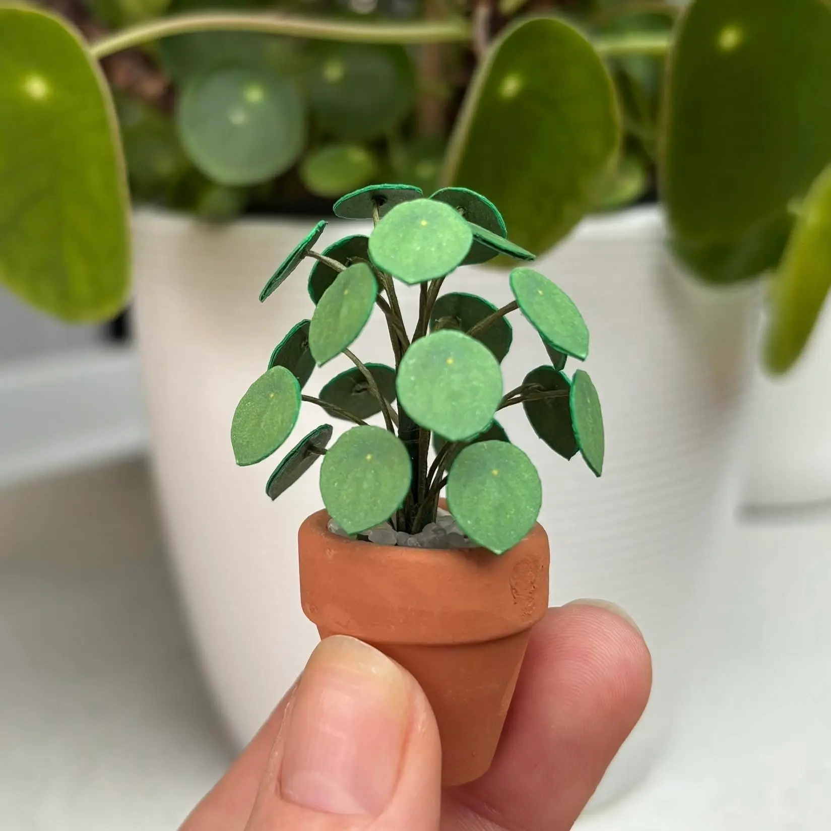 Tiny paper Pilea in a miniature terracotta pot.