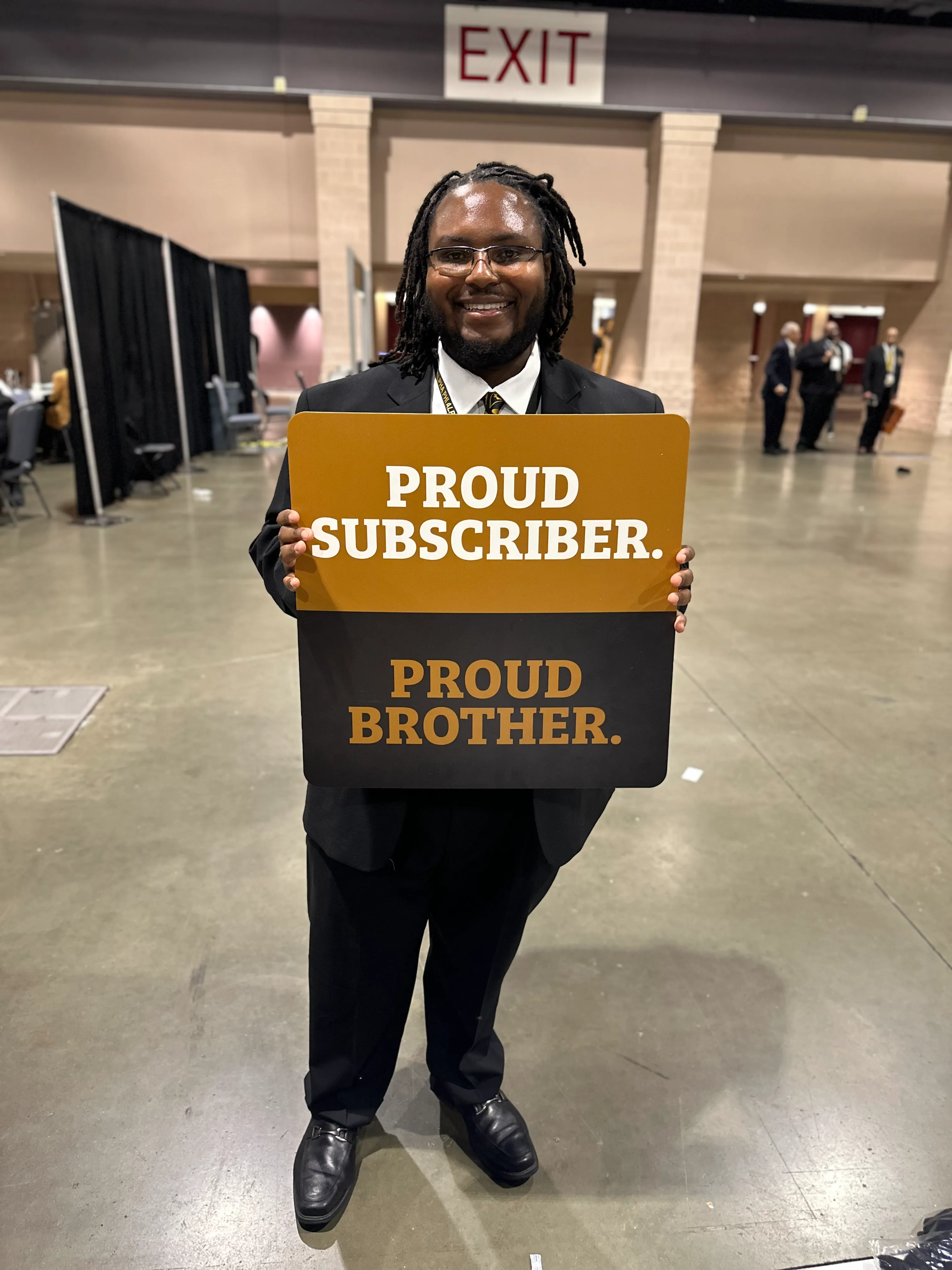 Alpha Phi Alpha brother wearing Alpha Traditions branded cap and jacket at a parade
