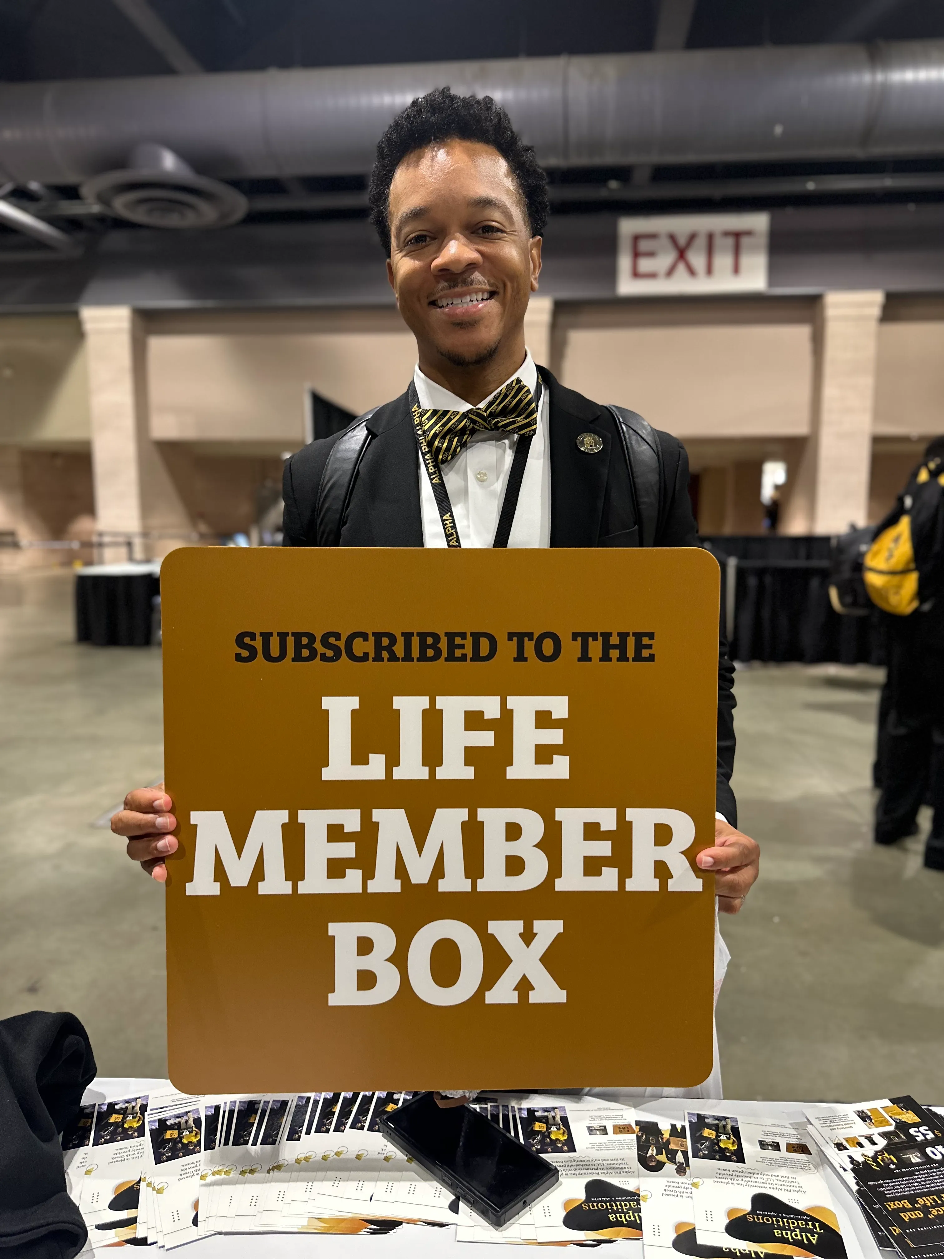 Customer showcasing Alpha Traditions accessories at a fraternity networking event