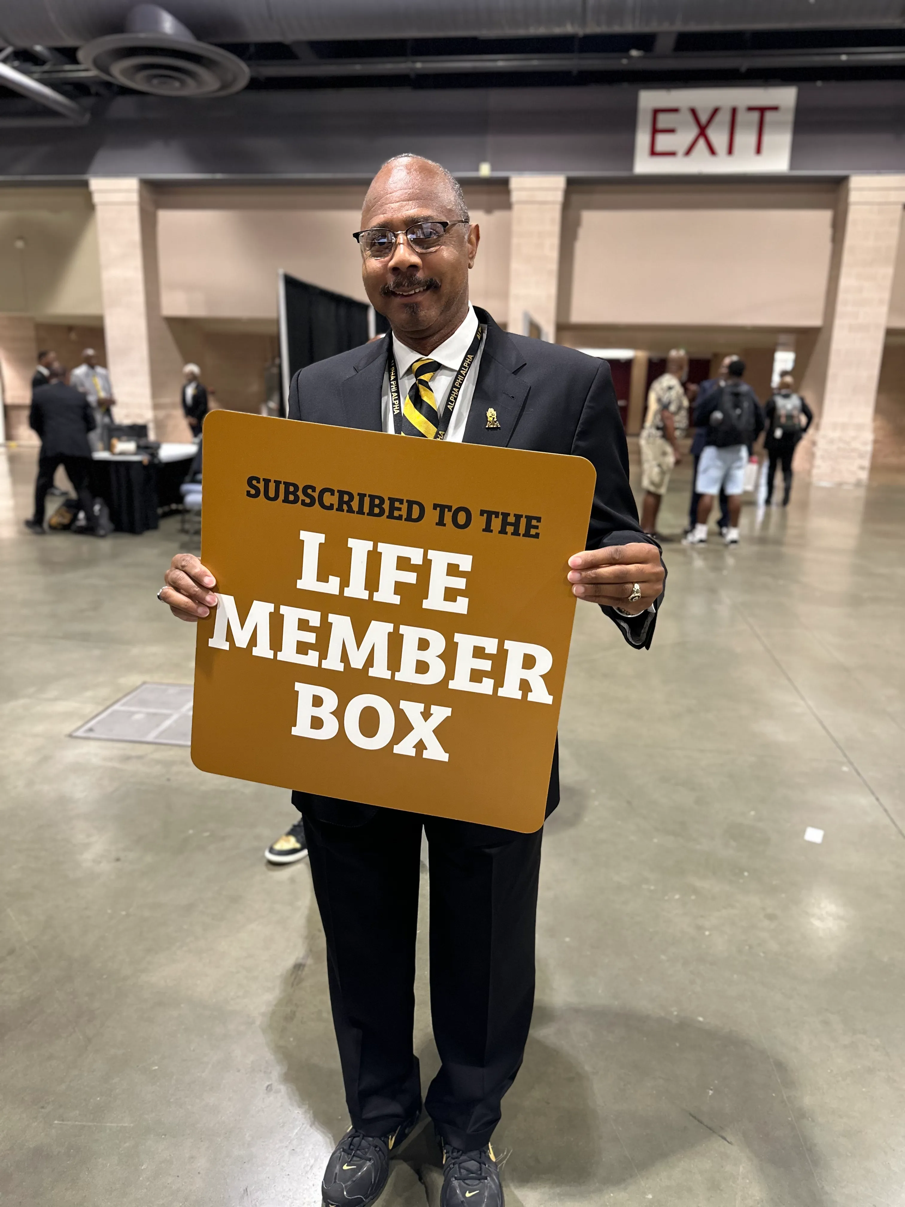 Alpha Phi Alpha member wearing Alpha Traditions premium varsity jacket at a formal dinner