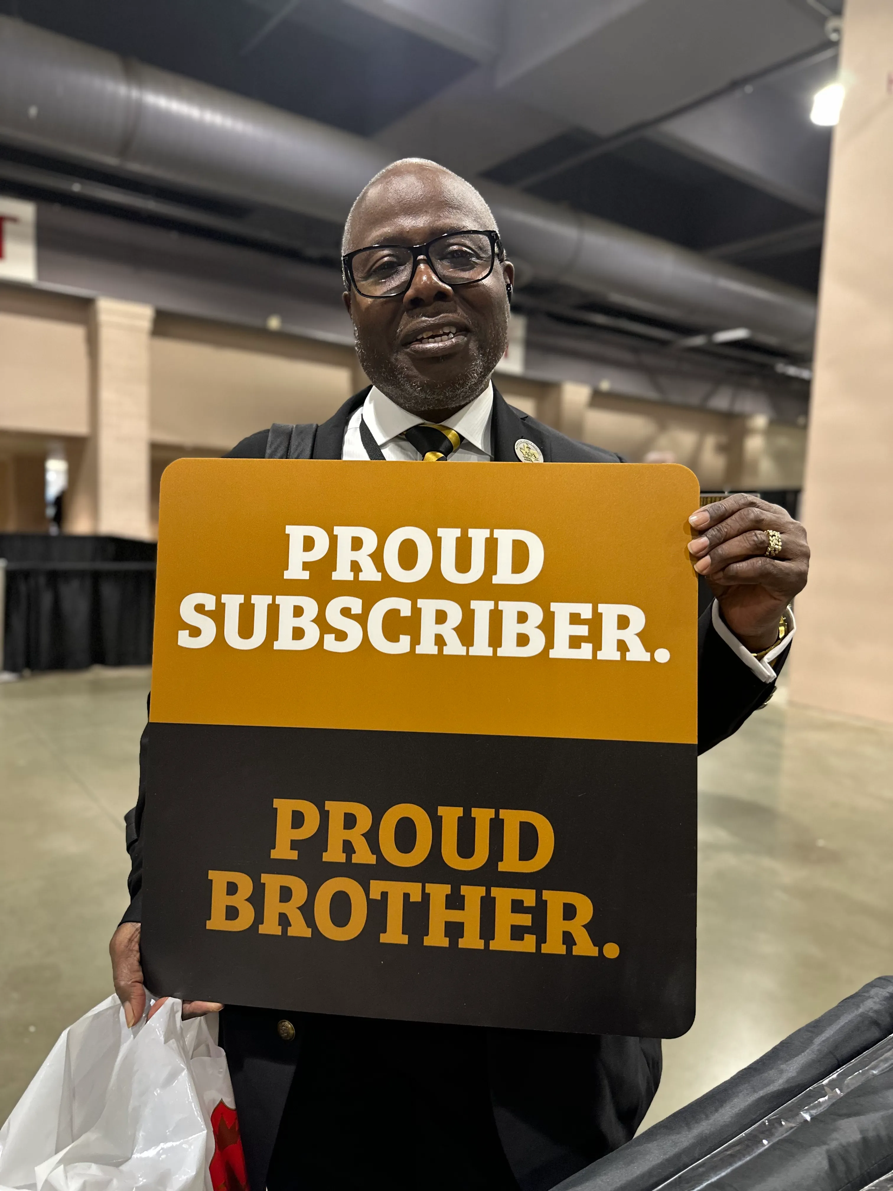 Alpha Phi Alpha member showcasing limited edition Alpha Traditions seasonal merchandise