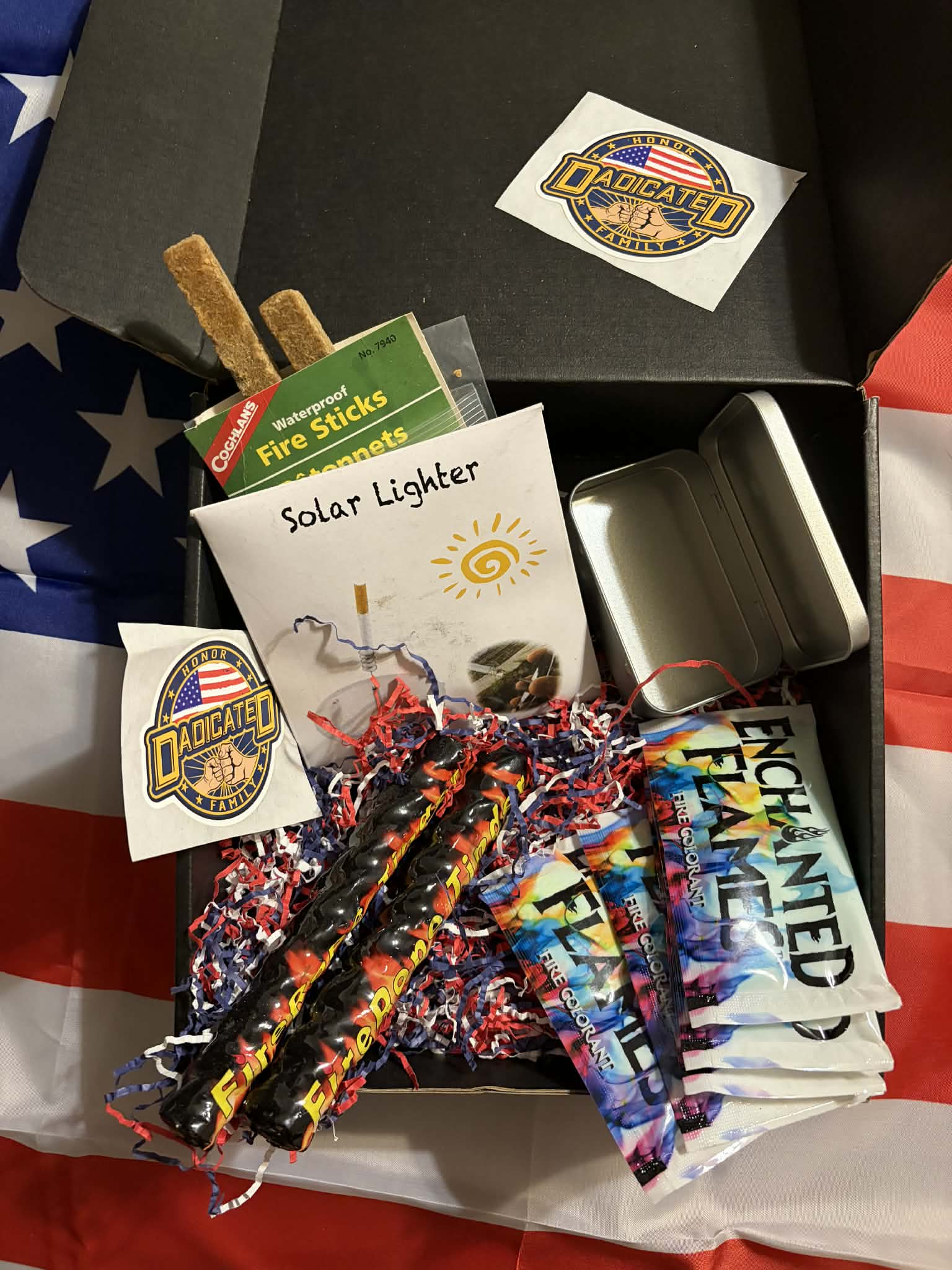 DADicated campfire box with fire sticks, solar lighter, and enchanted flame colorants on American flag