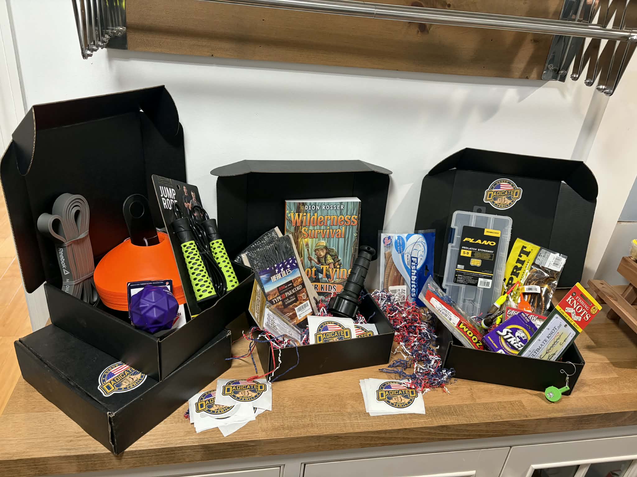 Three DADicated themed subscription boxes — fitness, wilderness survival, and fishing — displayed together