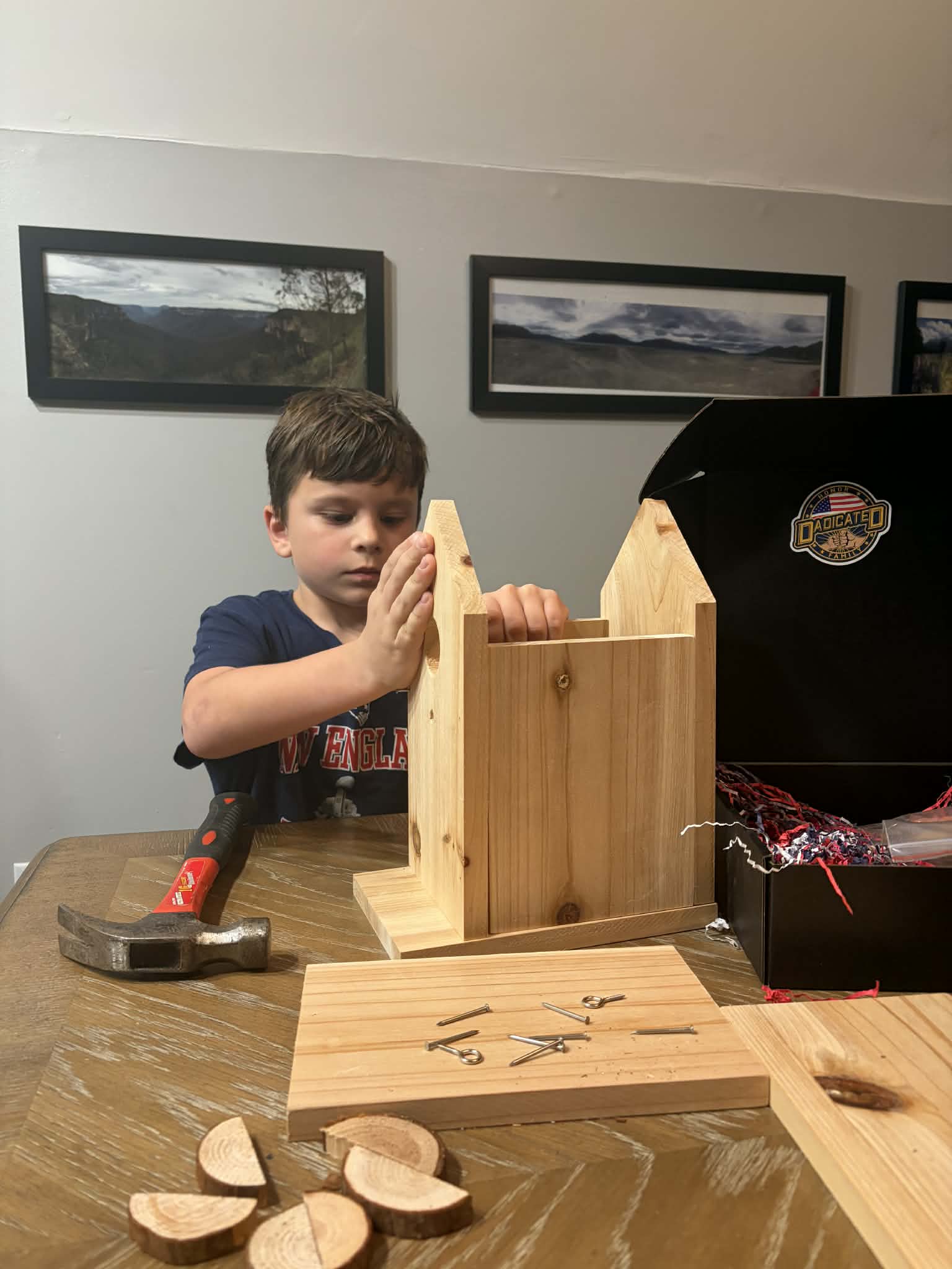 Boy focused on building a wooden castle structure from a DADicated project kit