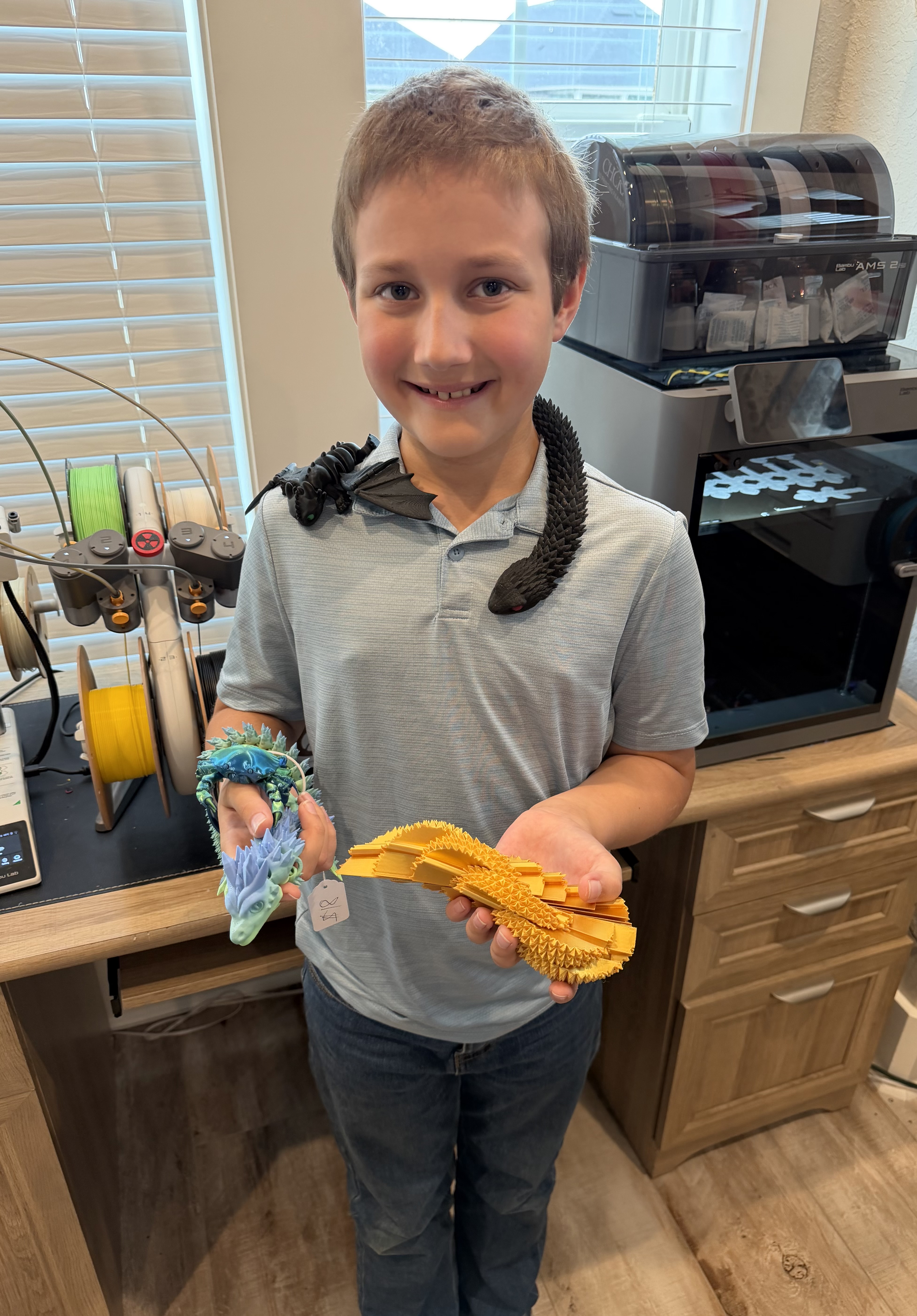 Aiden Creel holding 3D printed toys in his workshop