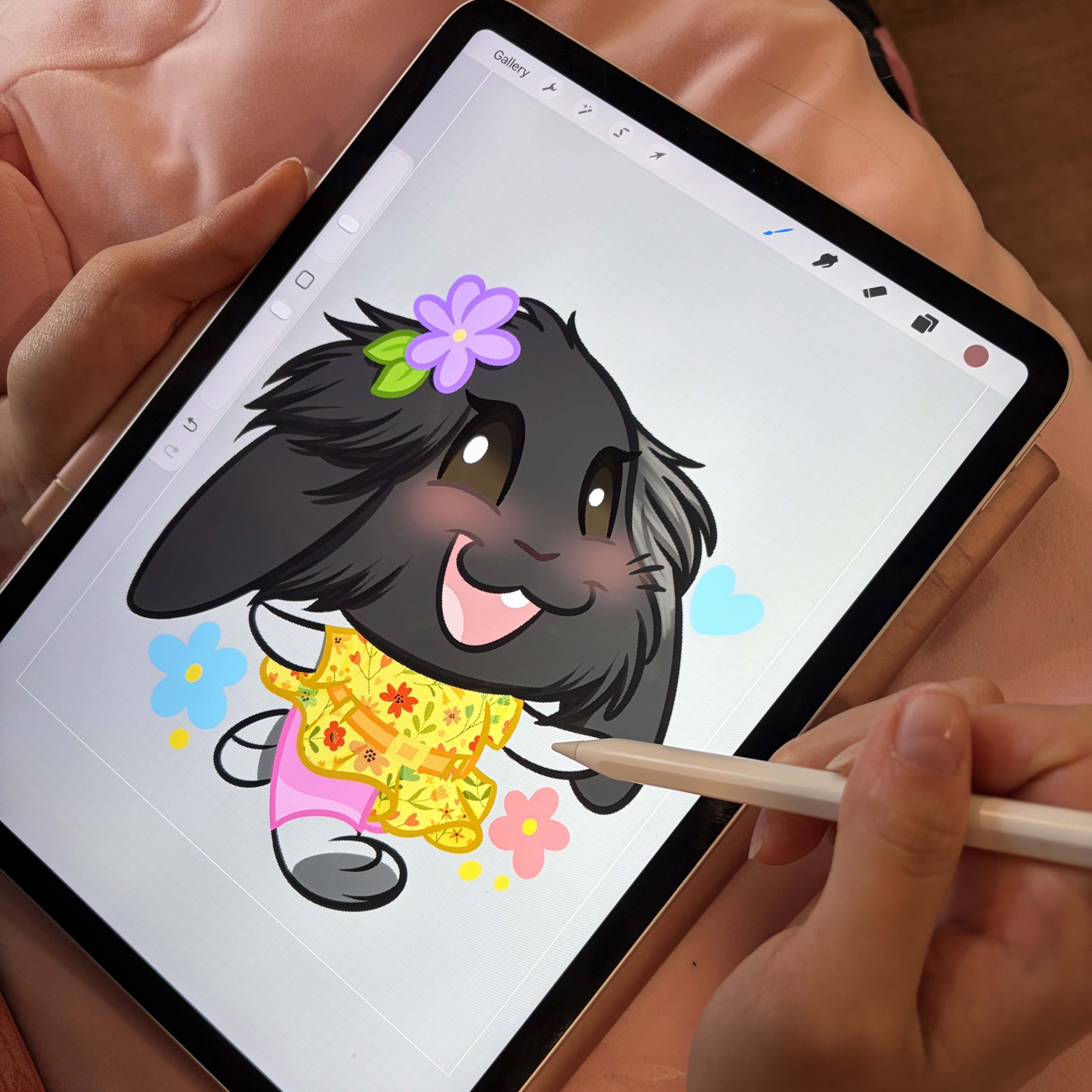 Hand illustrating bunny stickers on tablet