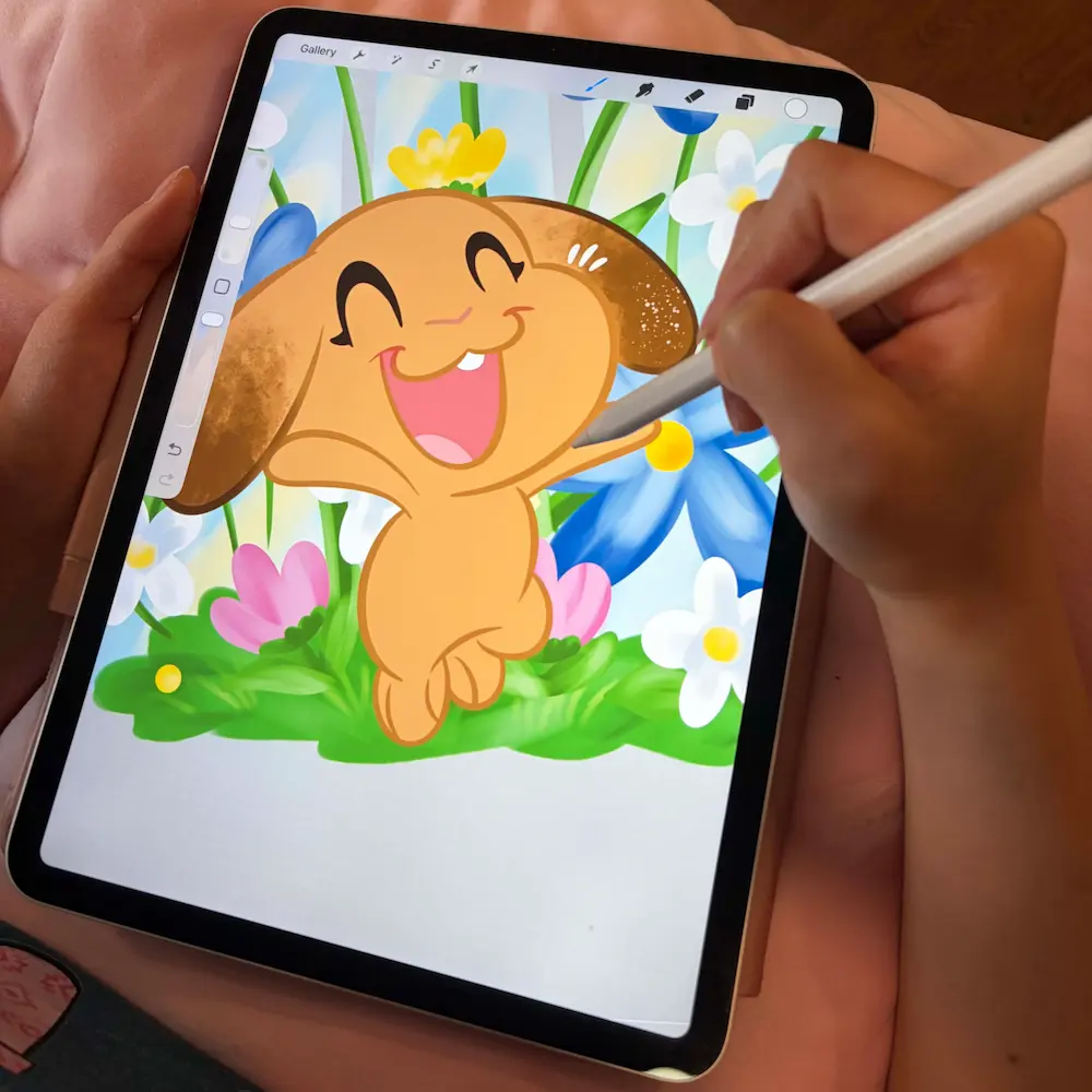 Hand illustrating bunny designs on tablet