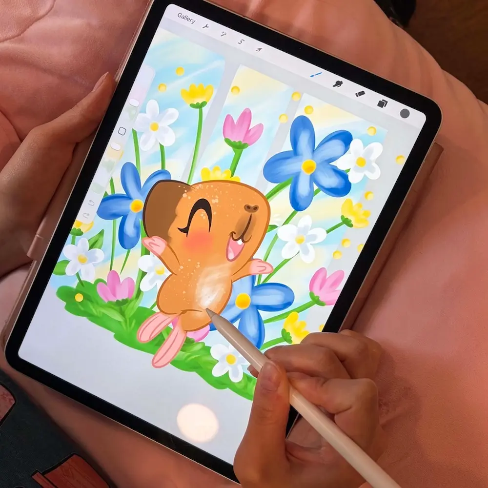 Hand illustrating piggie designs on tablet