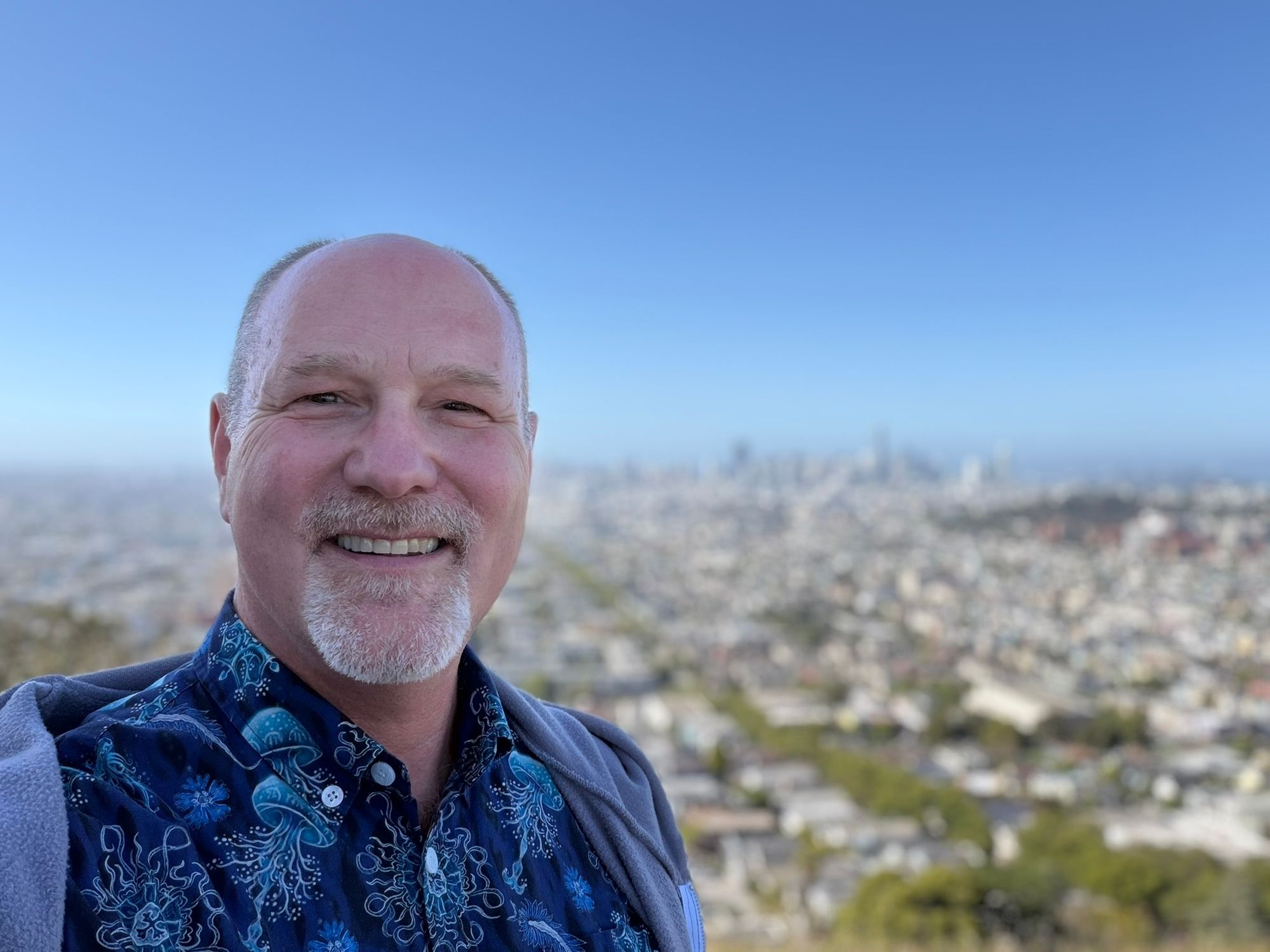 Paul Plamondon smiling with a city view behind him