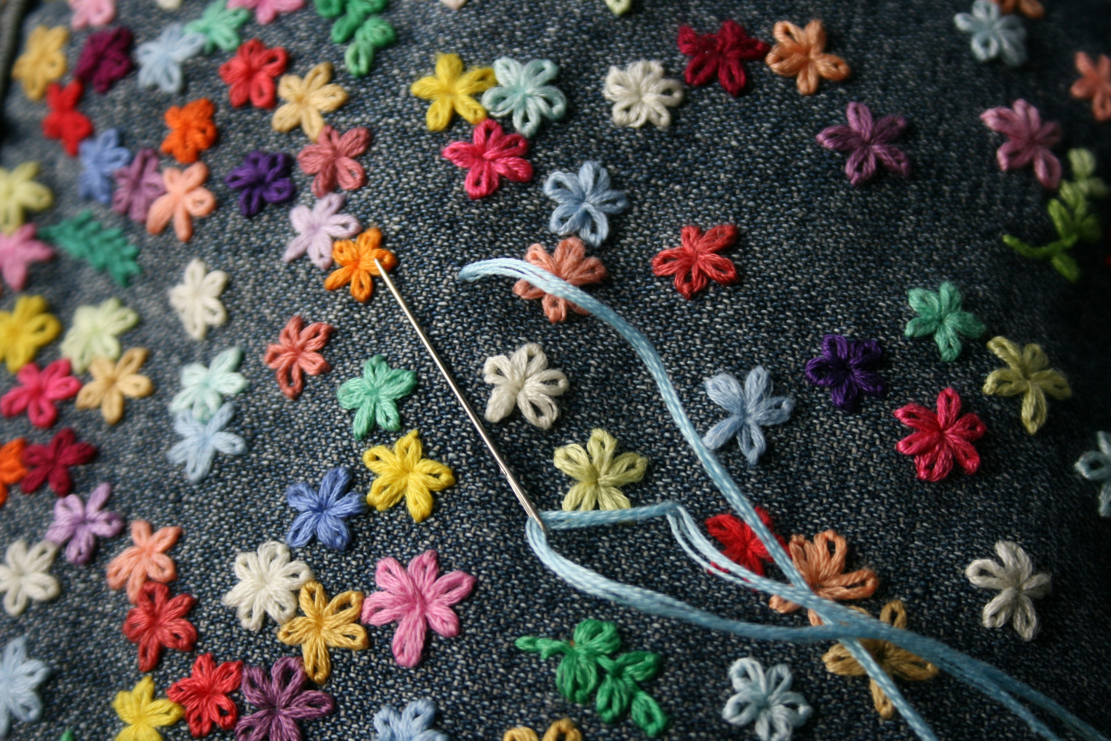 An embroidery hoop with botanical stitching on linen
